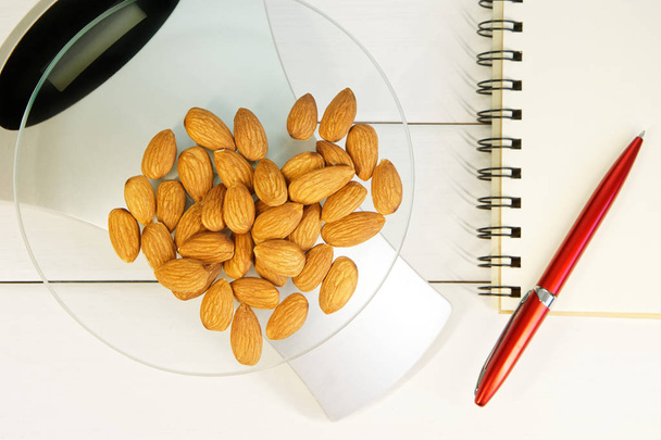 Počítání kalorií, bílkovin, tuků a sacharidů v potravinách. Mandlové ořechy na stolní váhy. - Fotografie, Obrázek