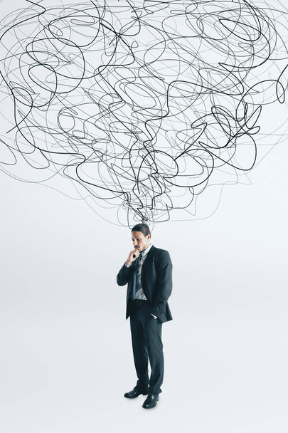 Thoughtful young businessman with scribble standing on white background. Confusion and doubt concept  - Foto, Bild