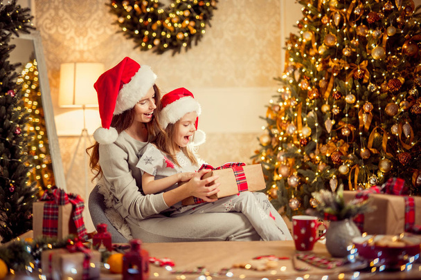 a happy family mother and child pack Christmas gifts - Foto, Imagen