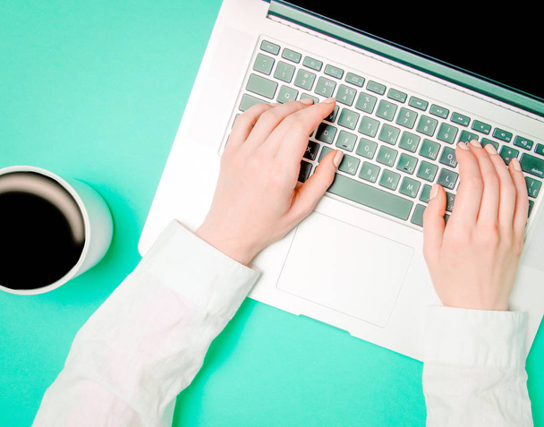 Mani femminili con tazza di caffè e laptop
 - Foto, immagini