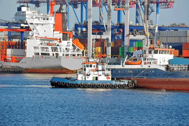 Rimorchiatore che assiste la nave merci alla rinfusa alla banchina del porto
 - Foto, immagini