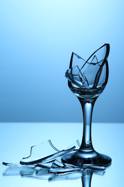 Broken wineglass on blue background - Foto, Imagem
