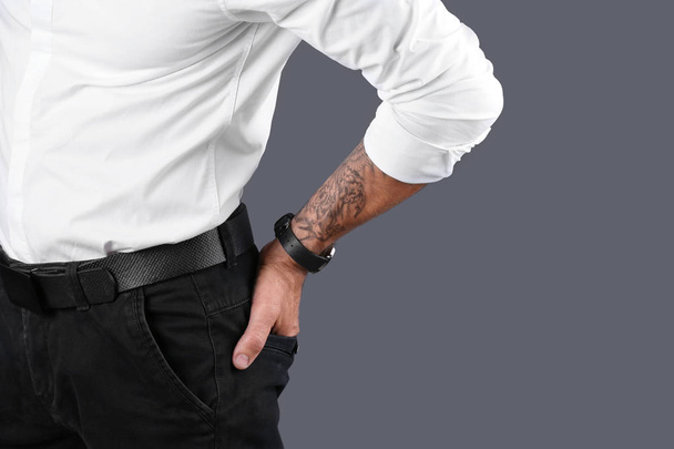 Close-up beeld van tattooed man op grijze achtergrond. Ruimte voor tekst - Foto, afbeelding