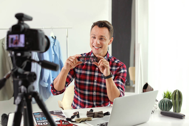 Fashion blogger with glasses recording video on camera at home - Valokuva, kuva