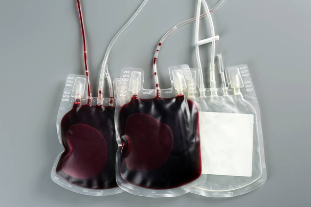 Blood packs on gray background, top view. Donation day - Zdjęcie, obraz