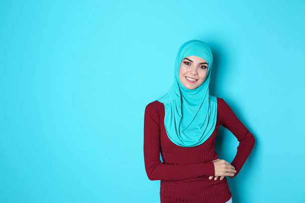 Portrait of young Muslim woman in hijab against color background. Space for text - 写真・画像