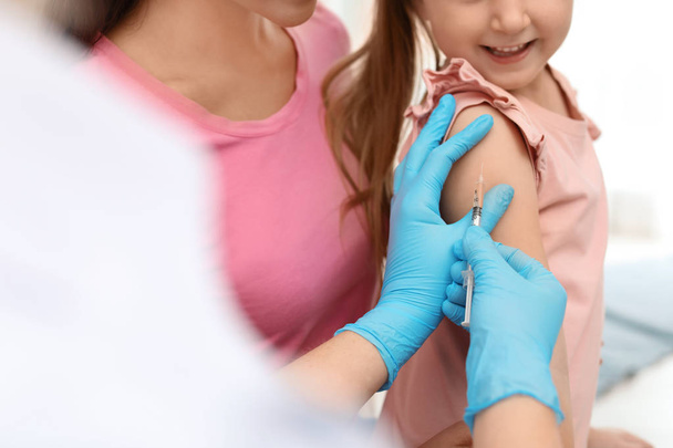 Children's doctor vaccinating little girl, closeup view - Фото, изображение