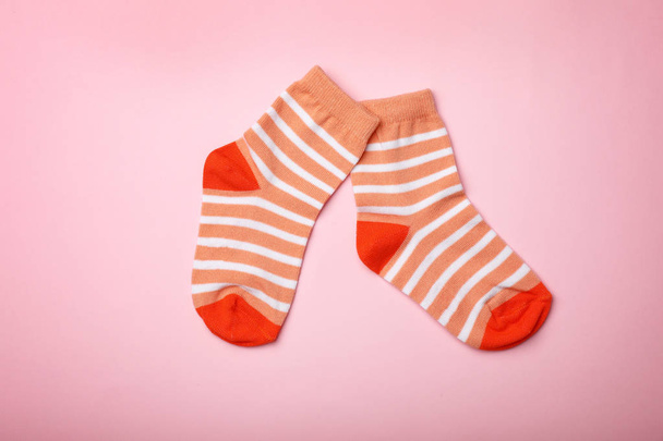 Cute child socks on color background, flat lay - Fotó, kép