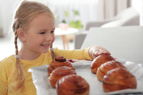 Little girl with tray of oven baked buns at home - Foto, immagini