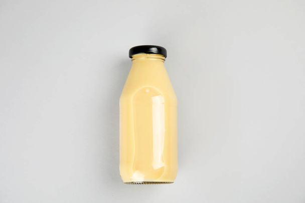 Una botella con sabrosa bebida sobre fondo de color, vista superior
 - Foto, Imagen