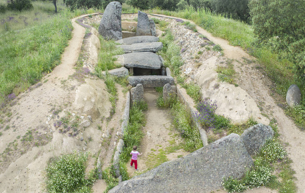 Pequeño visitante que descubre Dolmen de Lacara, antiguo edificio megalítico de Extremadura. España. Vista aérea
 - Foto, Imagen