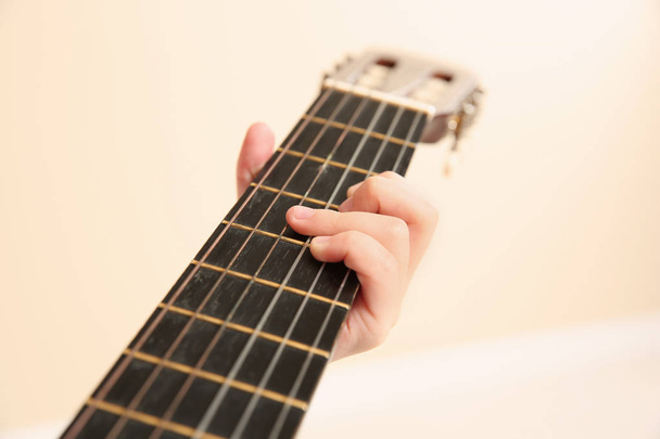 Little girl playing wooden guitar, closeup view - Photo, Image