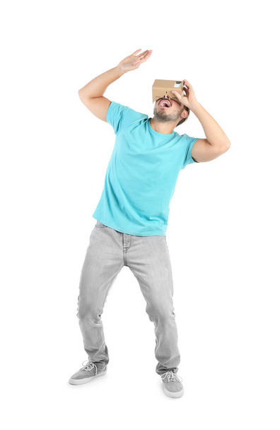 Young man using cardboard virtual reality headset, isolated on white - Photo, image