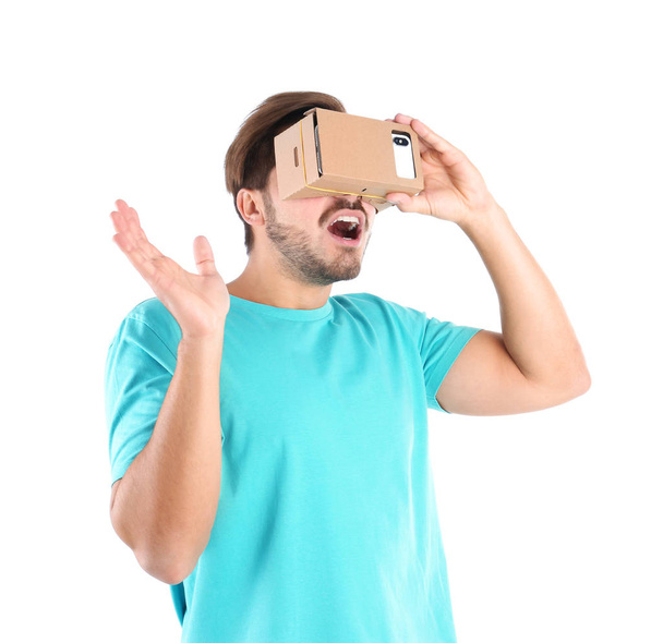 Young man using cardboard virtual reality headset, isolated on white - Foto, Imagen