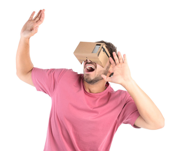 Young man using cardboard virtual reality headset, isolated on white - Foto, Imagem
