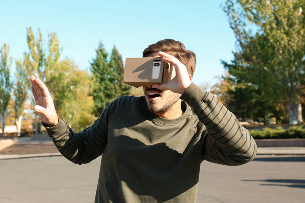 Young man using cardboard virtual reality headset outdoors - Zdjęcie, obraz