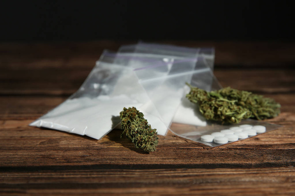 Cocaine, dried hemp and ecstasy on wooden table - Фото, зображення