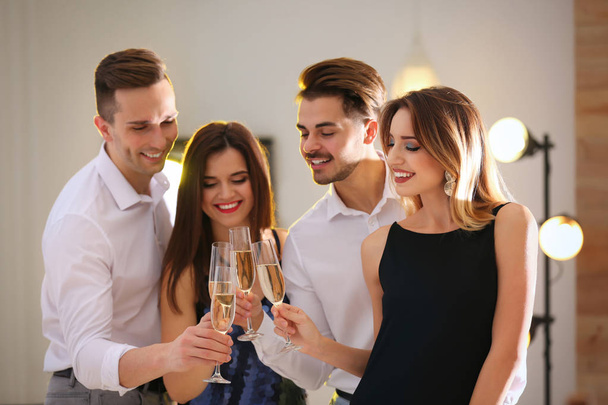Friends clinking glasses with champagne at party indoors - Photo, image