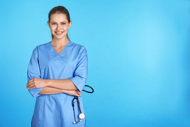 Portret młodego asystenta medycznego z stetoskop na kolor tła. Miejsca na tekst - Zdjęcie, obraz