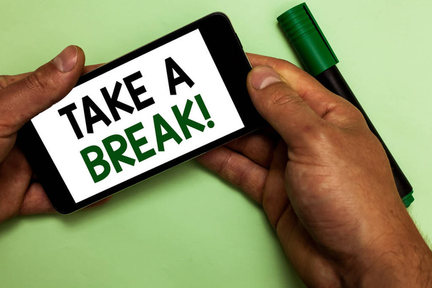 Writing note showing Take A Break. Business photo showcasing Resting Stop doing something recreation time get out of work Human hand hold iPhone with texts touched green marker. - Photo, Image