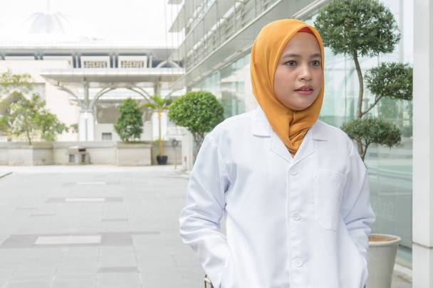 Confident female doctor standing infront of  office and smiling at camera, health care and prevention concept - Photo, Image