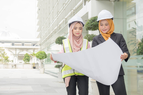 Professional woman engineers are discussing on construction at outdoor. - Photo, Image