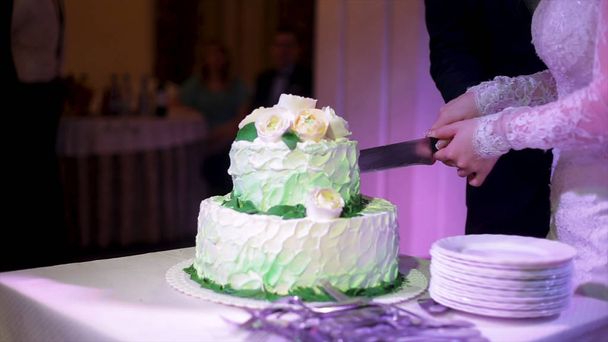 As noivas cortaram o bolo de casamento. Uma noiva e um noivo estão a cortar o bolo de casamento. Mãos de noiva e redução de noivo de uma parte de um bolo de casamento
 - Foto, Imagem