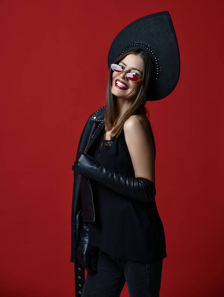 Portrait of brunette woman new fashion sunglasses and Russian traditional style kokoshnik hat on dark red background - Fotografie, Obrázek