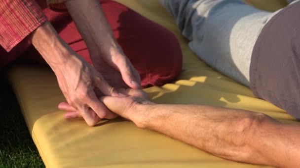 Relaxed man receiving hand massage outdoors. - Záběry, video