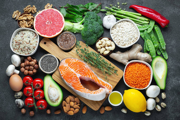 Alimentação saudável seleção de alimentação limpa: peixe, frutas, nozes, vegetais, sementes, superalimentos, cereais, vegetais de folha em fundo de concreto preto Flat lay
 - Foto, Imagem