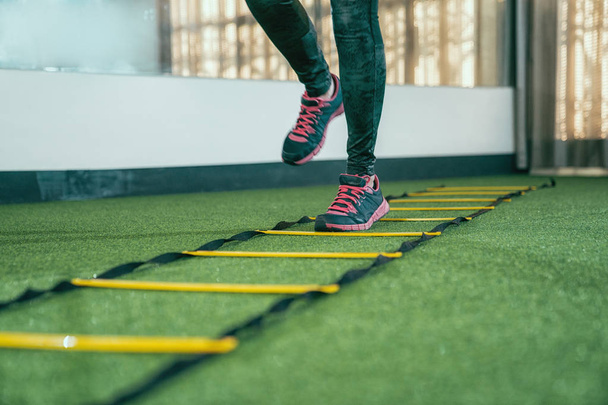 ismeretlen női sportoló gyakorló akadály futóverseny edzőteremben. cipők csinál edzés futtatása gyorsabb gyorsabb, a health Club összpontosítani a lábak. az emberek szeretik a sport gyakorlása életmód fogalma. - Fotó, kép