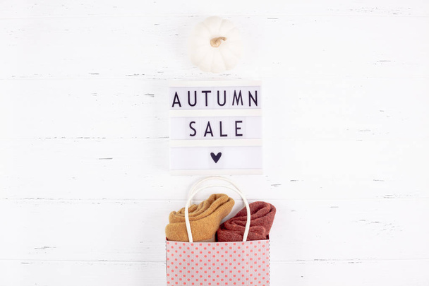 Creative Top view flat lay promotion composition Autumn sale text on lightbox white background copy space Template Autumn sale mockup fall seasonal offer promotion advertising with shopping bag - Foto, afbeelding