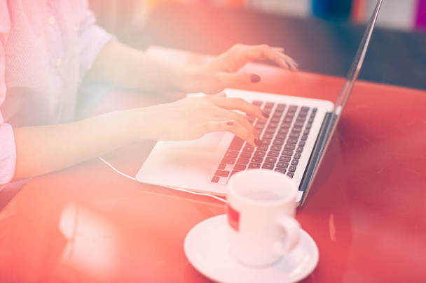 Mãos de mulher digitando no teclado de seu computador portátil. Feminino trabalhando em laptop em um café
. - Foto, Imagem