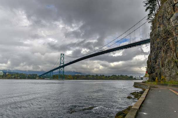 Lions Gate Bridge como visto de Stanley Park em Vancouver, Canadá. A Ponte do Portão dos Leões, inaugurada em 1938, oficialmente conhecida como Ponte das Primeiras Estreias, é uma ponte suspensa.
. - Foto, Imagem