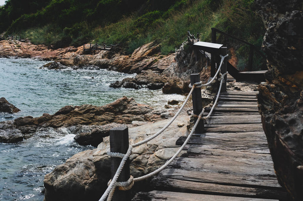 Madeira pequena ponte caminho para passear ao lado da praia com natureza verde em torno de fundo
. - Foto, Imagem