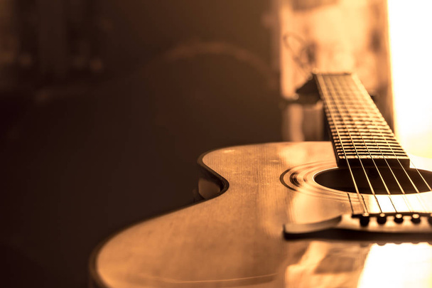 Ακουστική κιθάρα γκρο πλαν σε ένα όμορφο έγχρωμο φόντο, η έννοια των έγχορδων οργάνων - Φωτογραφία, εικόνα