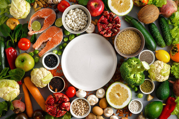 Empty round plate with set of healthy and diet food (cereals, seeds, fish, vegetables and fruits) - Valokuva, kuva