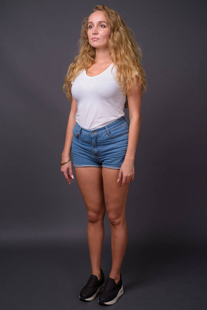 Full length portrait of young beautiful woman with long wavy blond hair - Fotoğraf, Görsel
