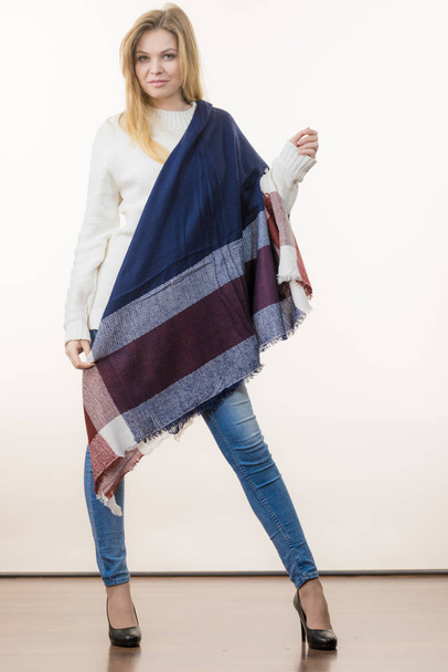 Woman feeling comfortable wearing her soft colorful warm autumnal shawl scarf. Blue jeans, high heels outfit. Autumn outfit accessories concept. - Fotó, kép