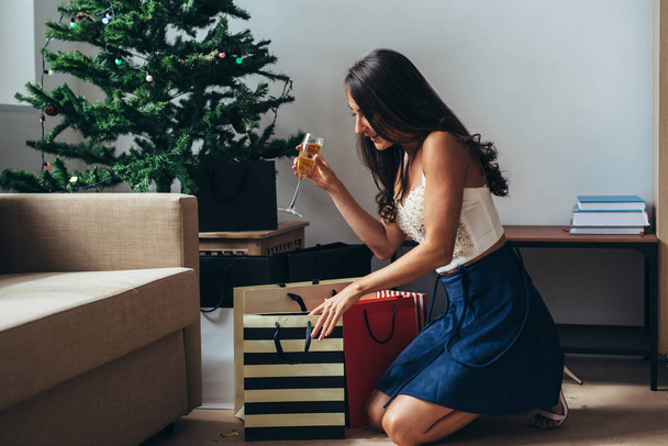 Yeni yıl. Alışveriş torbaları evde olan mutlu kadın - Fotoğraf, Görsel