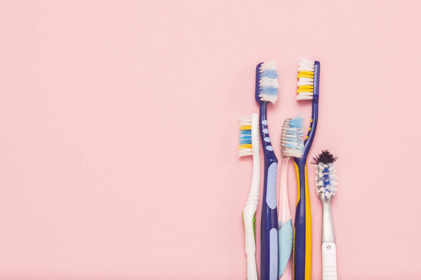 Diversi diversi spazzolini da denti usati su uno sfondo rosa. Cambio di spazzolino, igiene orale, famiglia grande e amichevole, selezione di spazzolini da denti. Posa piatta, vista dall'alto
 - Foto, immagini