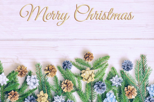 Χριστουγεννιάτικη σύνθεση από κλαδιά έλατου διακοσμημένα με τόξα και κουκουνάρια - Φωτογραφία, εικόνα