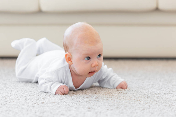 Child, childhood and infant concept - Pretty baby lie on the floor - Photo, Image