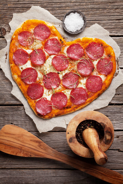 Heart shaped pizza with pepperoni and mozzarella. Valentines day greeting card. Top view - Photo, Image