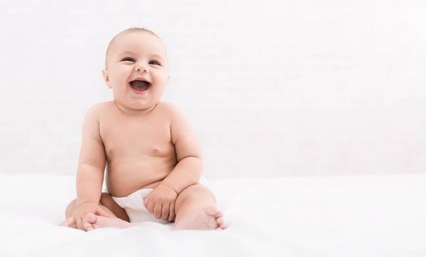 niedliches Baby sitzt auf weißem Hintergrund, Kopierraum - Foto, Bild