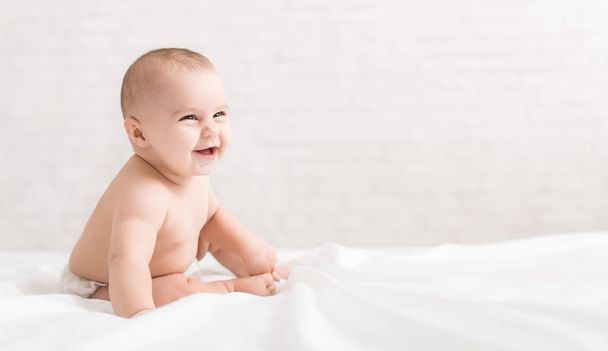Beautiful laughing baby sitting on white background - Photo, Image