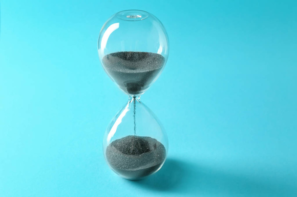 Hourglass on color background. Time management concept - 写真・画像