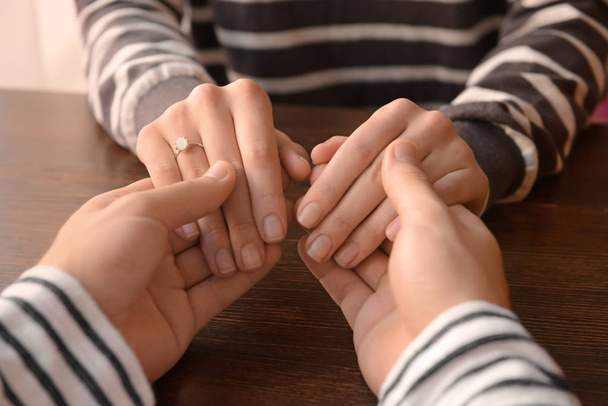 Любящие молодые пары держатся за руки за столом, крупным планом
 - Фото, изображение