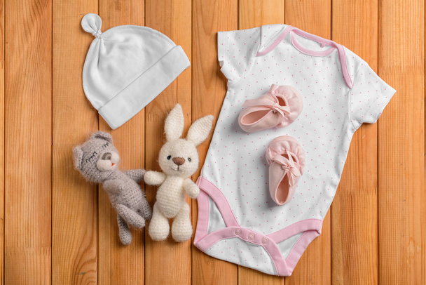 Bebek Giyim ve oyuncak ahşap arka plan, düz yatıyordu - Fotoğraf, Görsel