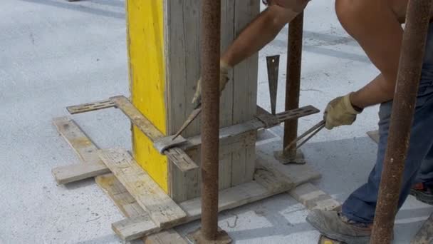 працівник підсилює дерев'яну опалубку сталевими стяжками
 - Кадри, відео